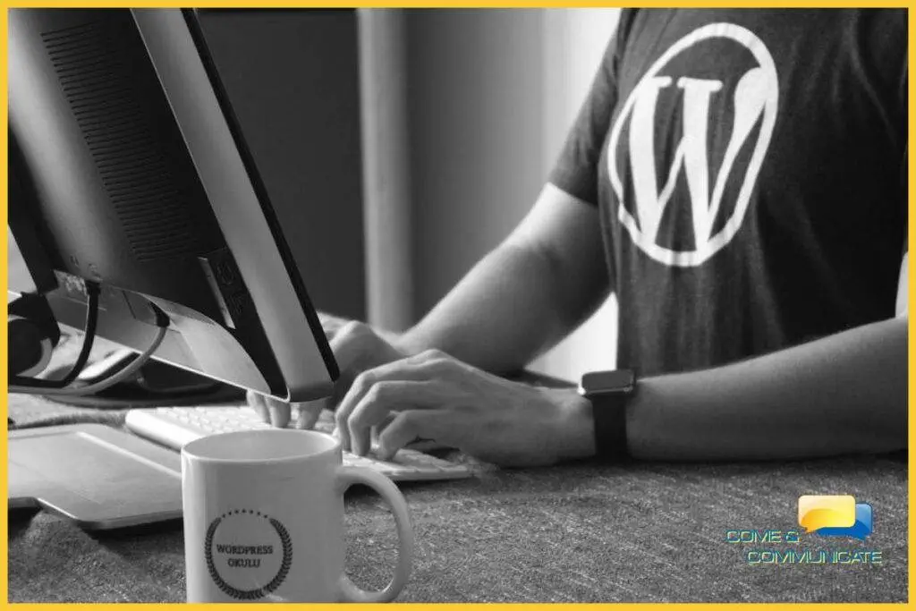 Chico con una camiseta con el logo de WordPress y tecleando en un ordenador de sobremesa