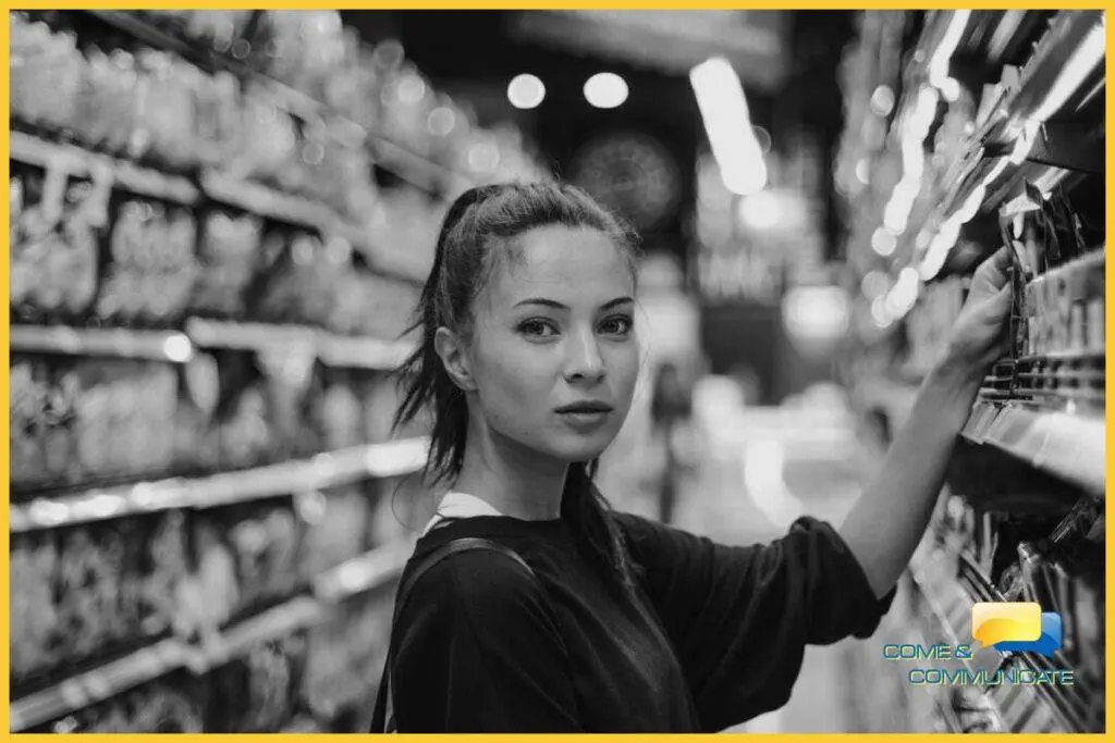 Mujer joven cogiendo un producto del lineal de un supermercado