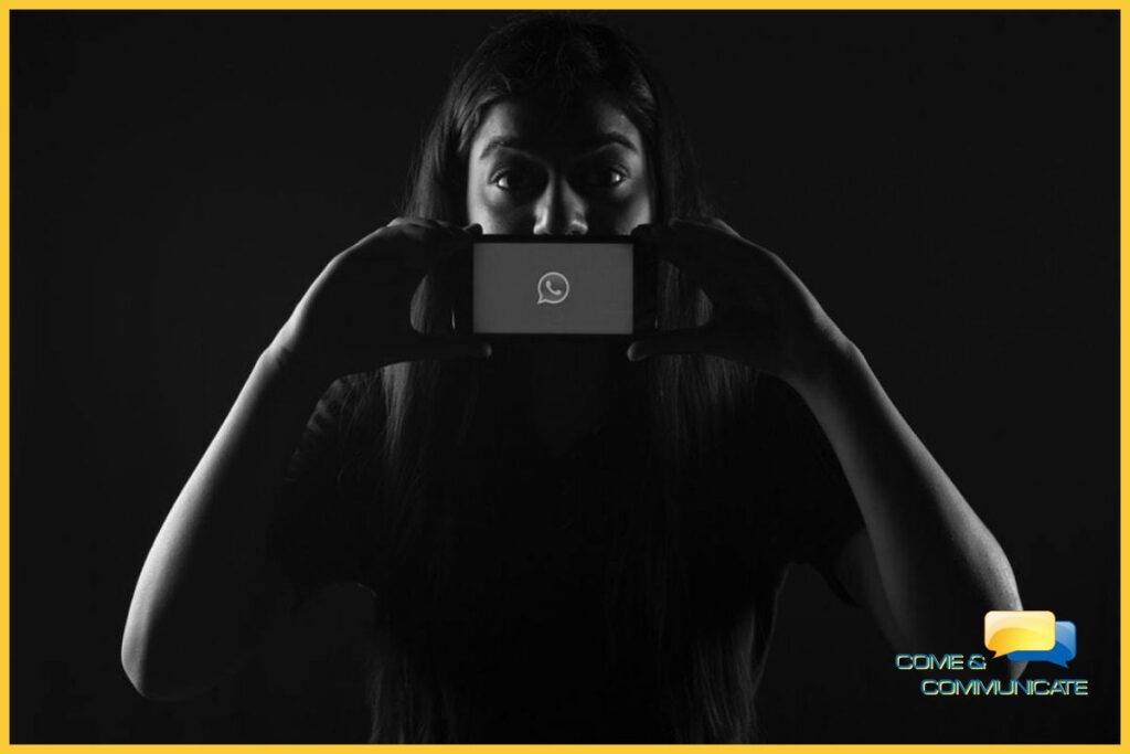 ¿Cuáles son las ventajas de una estrategia de comunicación omnicanal? Una mujer tapando su boca con un teléfono móvil donde se ve el símbolo de Whatsapp