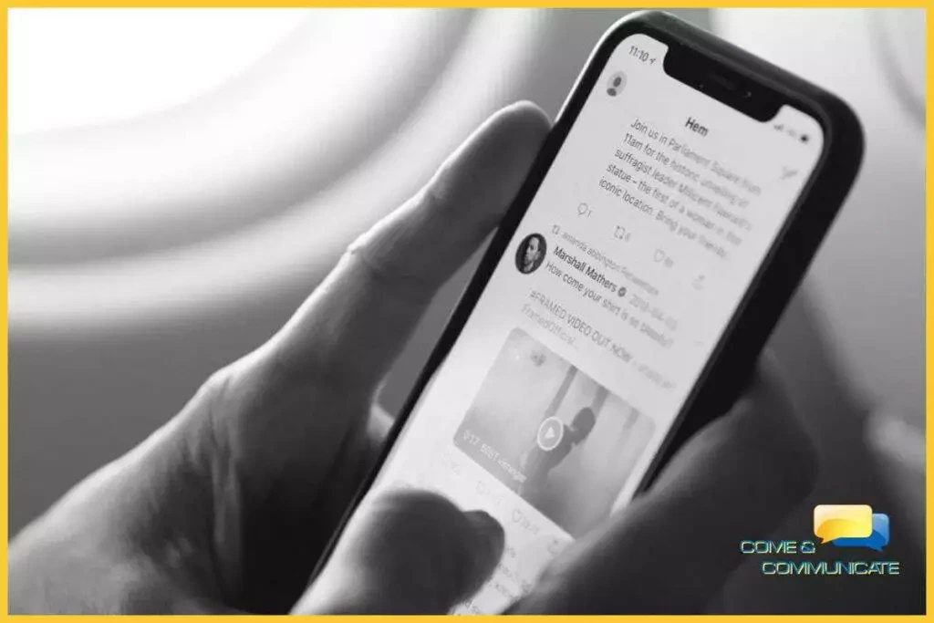 Manos controlando un móvil y mostrando en la pantalla el timeline de Twitter.