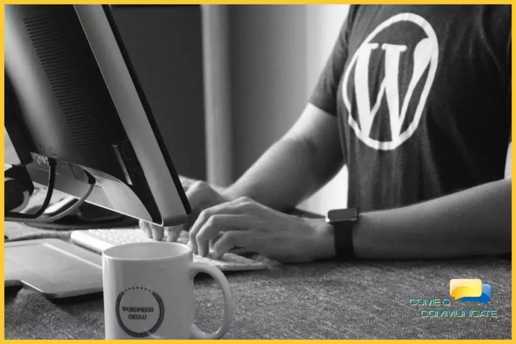 Chico con una camiseta con el logo de WordPress y tecleando en un ordenador de sobremesa