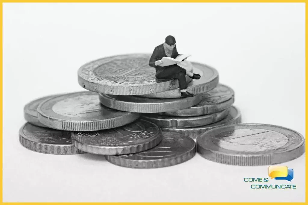 Figura de juguete leyendo el periódico encima de un montón de euros.