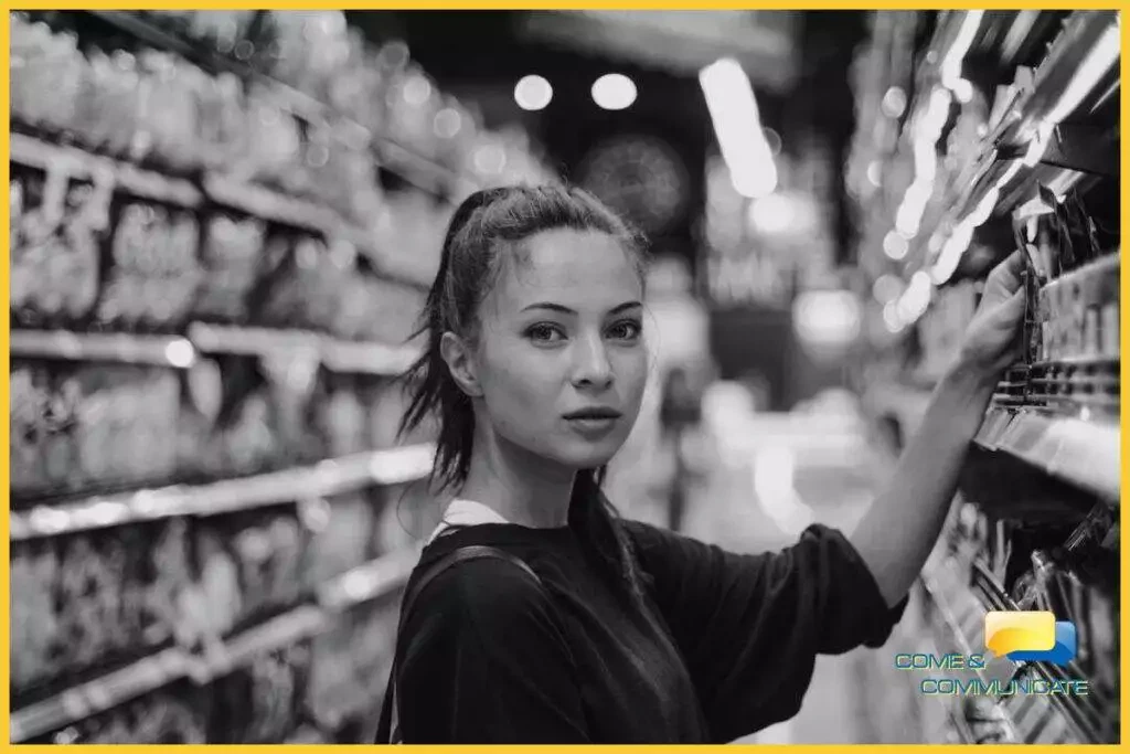 Mujer joven cogiendo un producto del lineal de un supermercado
