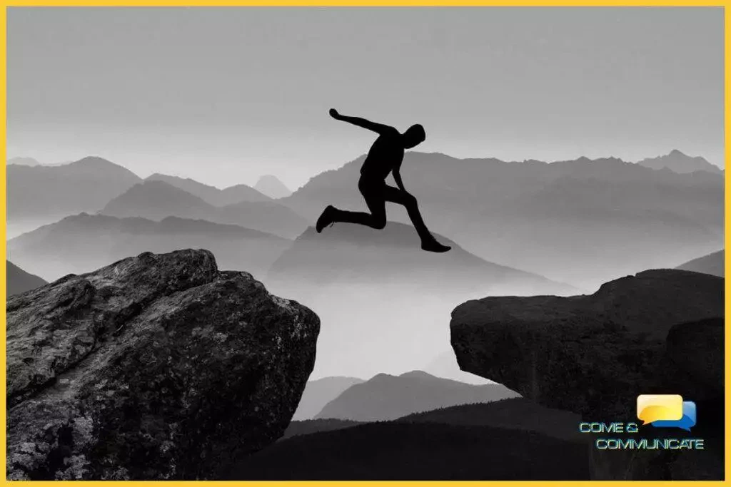 Silueta negra de un chico saltando de una roca a otra