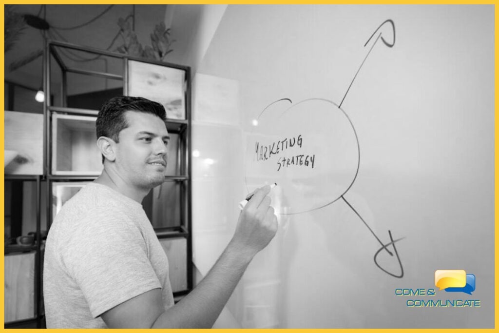 Un hombre dibujando en una pizarra blanca estrategias de marketing para la monetización de páginas web