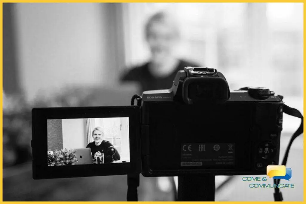 Primer plano de una cámara grabando a una mujer grabándose para crear un webinar para sus afiliados.