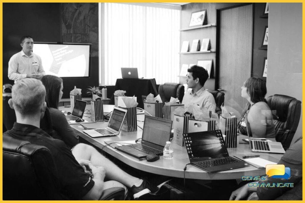 Grupo de trabajadores informáticos reunidos trabajando en un proyecto web.