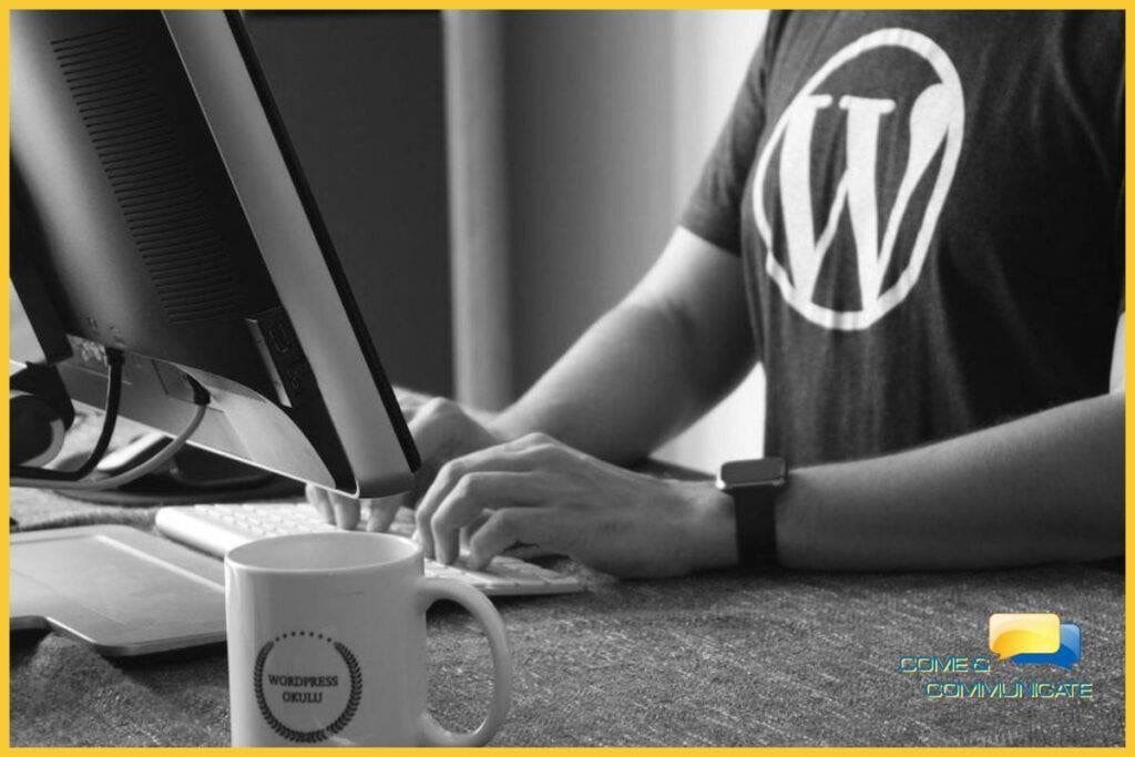 Chico con una camiseta con el logo de WordPress y tecleando en un ordenador de sobremesa