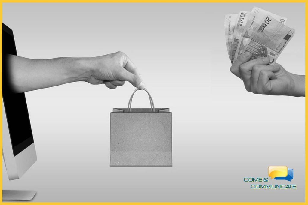Mano saliendo de un ordenador y entregando una bolsa a una mano que le entrega el dinero por el pedido