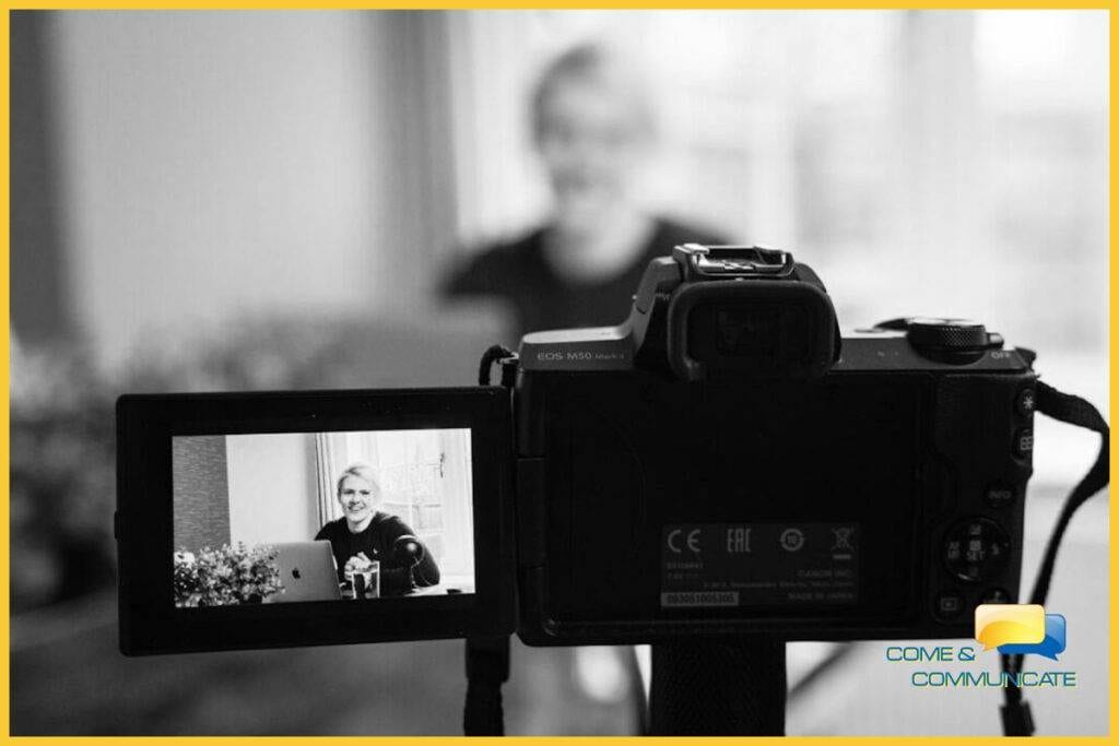 Primer plano de una cámara grabando a una mujer grabándose para crear un webinar para sus afiliados.