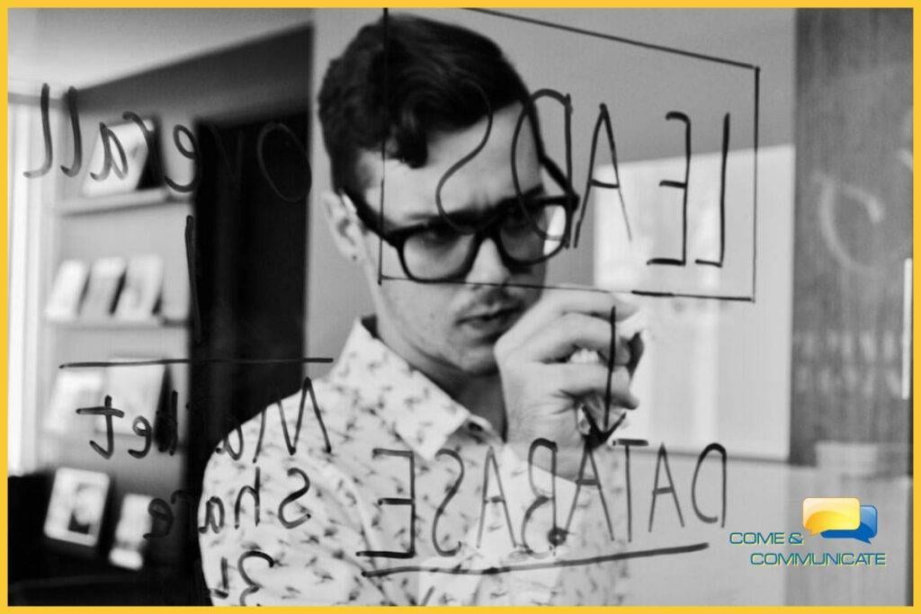 Especialista en marketing diseñando una estrategia de analítica digital mediante el análisis de métricas y bases de datos en un panel de cristal.